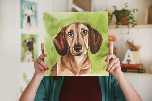 Artist hiding behind aquarelle of a dachshund - RTBF00459