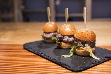 Mini burgers of red tuna on a slate board - ABZF01368