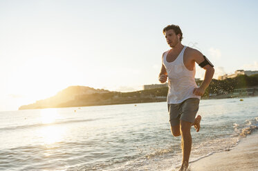 Spain, Mallorca, Jogger at the beach in the morning - DIGF01367