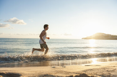 Spain, Mallorca, Jogger at the beach in the morning - DIGF01370