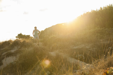 Spain, Mallorca, Jogger in dune at sunrise - DIGF01376