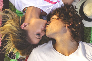 Junges Paar küsst sich auf einer Decke - DAPF00376