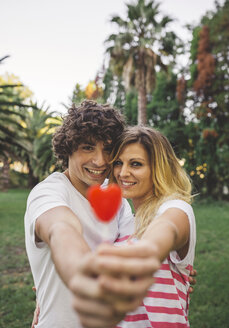 Young couple holding heart-shaped lollipops - DAPF00397