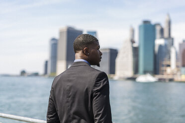 USA, Brooklyn, businessman looking at skyline of Manhattan - GIOF01472