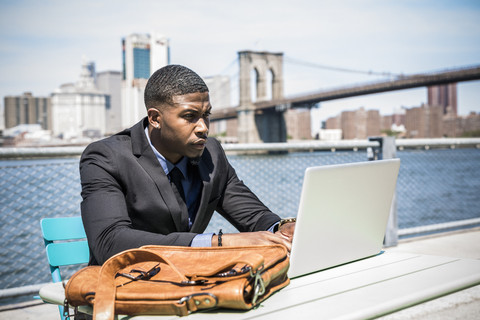 USA, Brooklyn, Geschäftsmann arbeitet mit Laptop im Freien, lizenzfreies Stockfoto