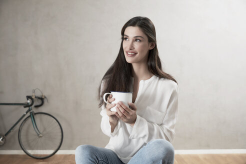Porträt einer lächelnden Frau, die sich mit einer Tasse Kaffee entspannt - FMKF03095