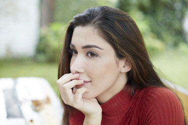 Portrait of smiling woman with hand on chin - FMKF03103