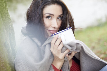 Porträt einer lächelnden Frau mit Kopftuch, die sich bei einer Tasse Kaffee entspannt - FMKF03107