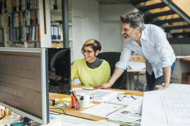 Männliche und weibliche Architekten besprechen ihre Arbeit im Büro - TCF05133