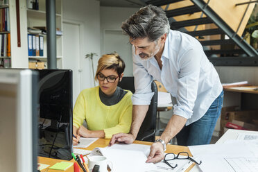 Männliche und weibliche Architekten besprechen ihre Arbeit im Büro - TCF05134