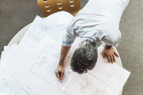 Architect working on ground plan in office - TCF05144