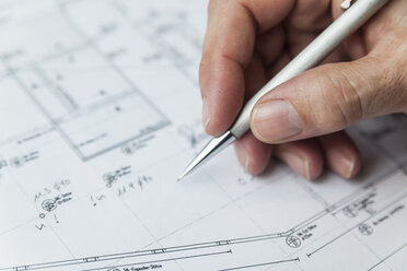 Hand of architect writing on ground plan - TCF05155