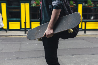 Junger Mann mit Skateboard und Rucksack, Teilansicht - BOYF00605