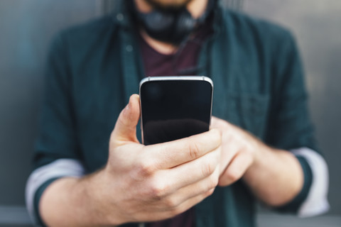 Hands of man holding smartphone, close-up stock photo