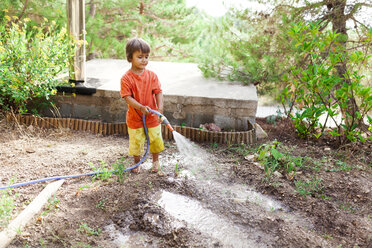 Kleiner Junge bewässert Obstgarten mit Gartenschlauch - VABF00811