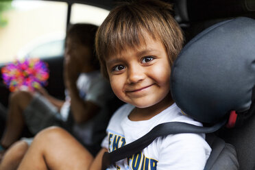 Portrait of smiling little boy sitting on backseat of a car - VABF00816