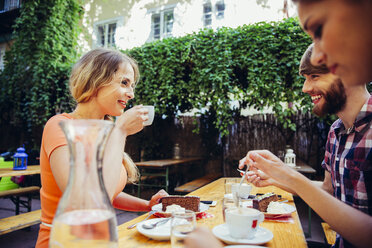 Freunde sitzen im Freien bei Kaffee und Kuchen - AIF00379