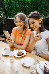 Zwei junge Frauen mit Handyfoto in einem Straßencafé - AIF00393