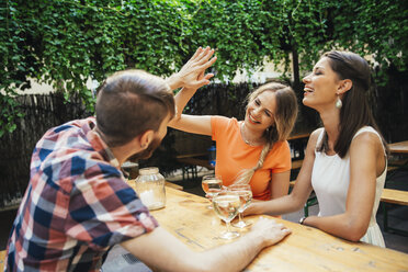 Fröhliche Freunde trinken Schorle in einer Kneipe im Freien - AIF00400