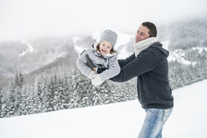 Vater spielt mit Tochter in Winterlandschaft - HAPF00962