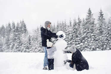 Familie baut gemeinsam Schneemann - HAPF00973