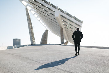 Businessman walking at solar panels - JRFF00933