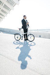 Geschäftsmann mit Fahrrad und Mobiltelefon - JRFF00952