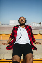 Man listening to music with headphones outside - JRFF00956