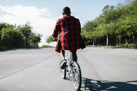 Mann fährt mit dem Fahrrad durch einen Park, lizenzfreies Stockfoto