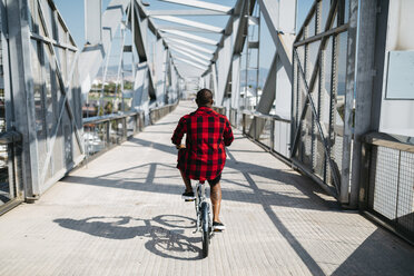 Mann fährt Fahrrad auf einer Brücke - JRFF00970