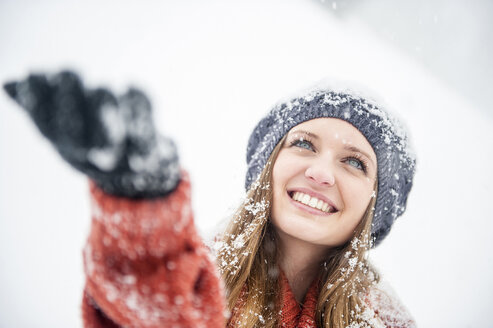 Lächelnde junge Frau bei starkem Schneefall - HHF05414