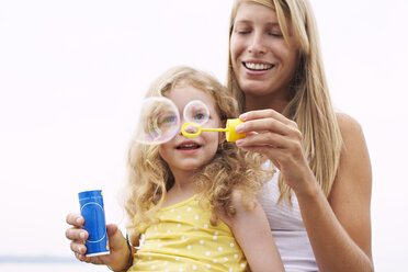 Mother and daughter blowing soap bubbles - FSF00579