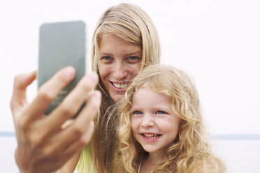 Lächelnde Mutter mit Tochter, die ein Selfie macht - FSF00586