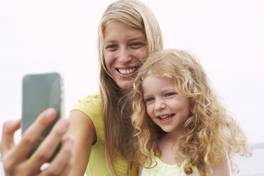 Smiling mother with daughter taking a selfie - FSF00587