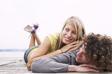 Smiling young couple lying on a jetty - FSF00594