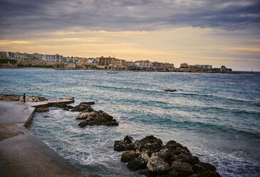 Italy, Otranto, Man looking at the sea - DIK00218