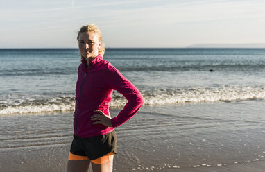 France, Crozon peninsula, sportive teenage girl standing on the beach - UUF08619