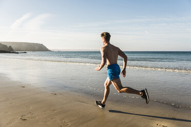 France, Crozon peninsula, young man running on the beach - UUF08627