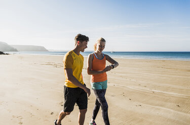 Frankreich, Halbinsel Crozon, sportliches junges Paar beim Spaziergang am Strand - UUF08633
