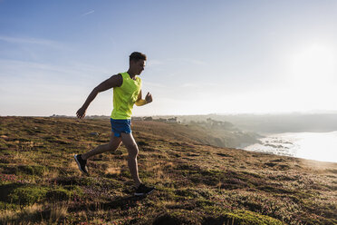 France, Crozon peninsula, young man running at the coast - UUF08672