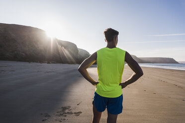 Frankreich, Halbinsel Crozon, sportlicher junger Mann am Strand stehend - UUF08676