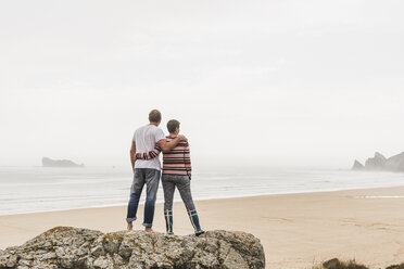 Frankreich, Bretagne, Halbinsel Crozon, Paar auf Felsen am Strand stehend - UUF08728