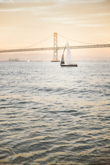 USA, San Francisco, Segelboot gegen Bay Bridge bei Sonnenuntergang - EPF00161