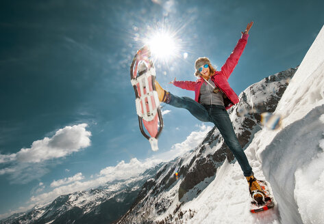 Österreich, Land Salzburg, Junge Frau beim Schneeschuhwandern in den Bergen - HHF05424