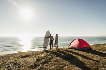 Junges Paar mit Surfbrett beim Camping am Meer - UUF08753