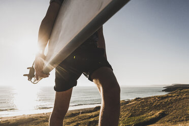 Teenage boy with surfboard at seaside, partial view - UUF08761