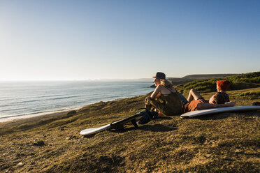 Drei Freunde mit Surfbrettern entspannen sich am Meer - UUF08770