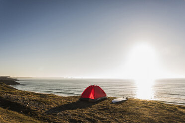Rotes Zelt und Surfbrett am Meer in der Abenddämmerung - UUF08776