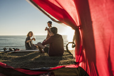 Three friends camping at seaside - UUF08789