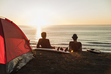 Two best friends enjoying sunset on the beach - UUF08808